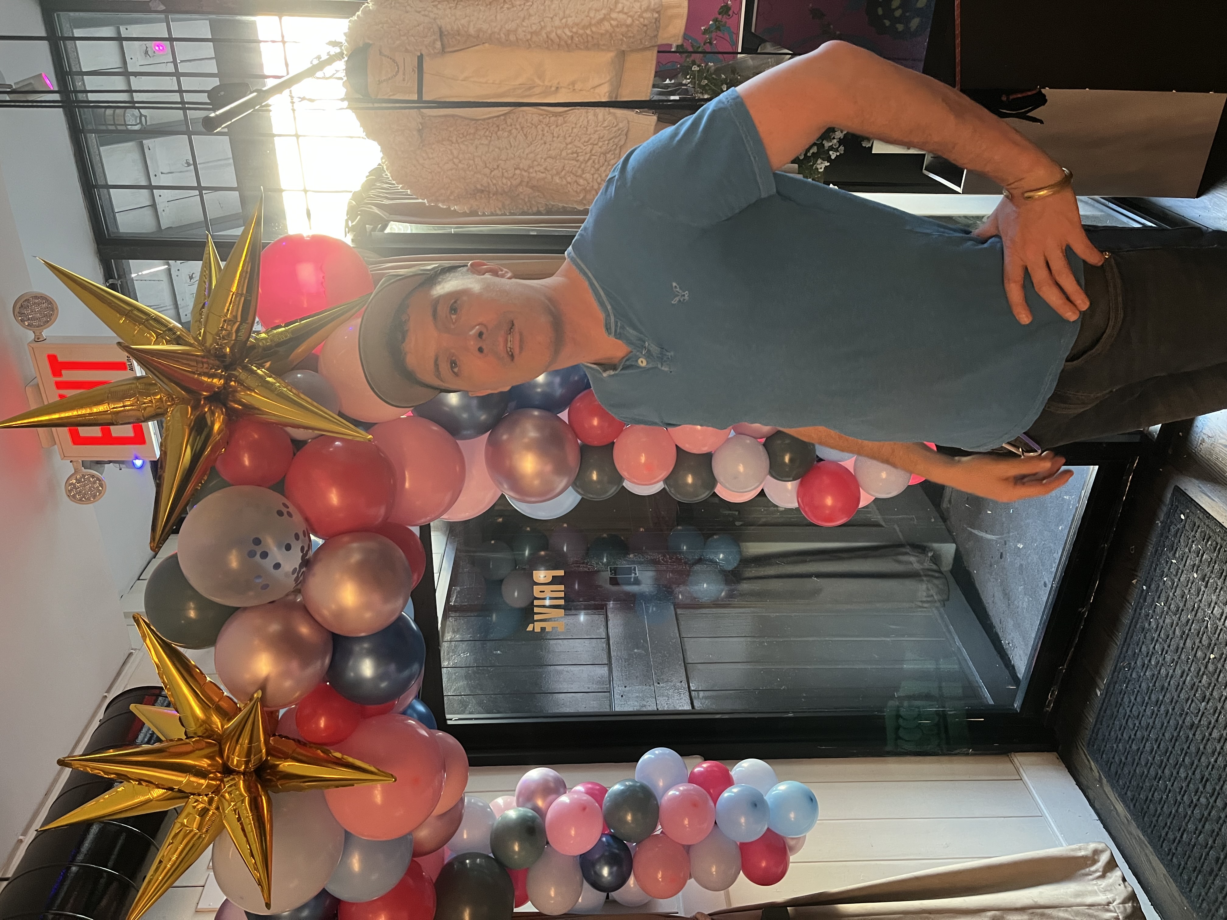 A multi-colored balloon garland draped over an entrance to music event