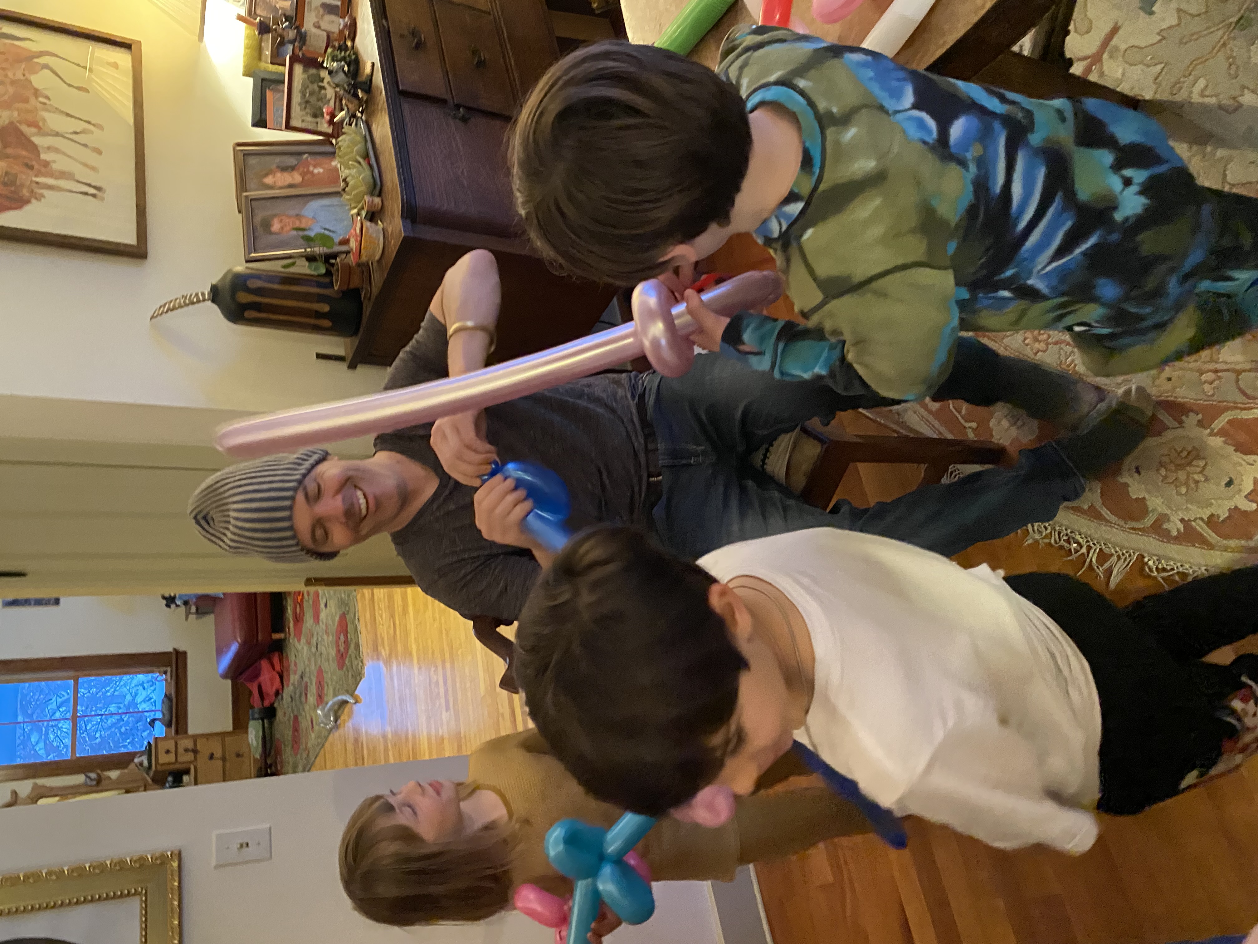 Balloon artist entertaining kids with balloon swords at a DUMBO loft birthday party