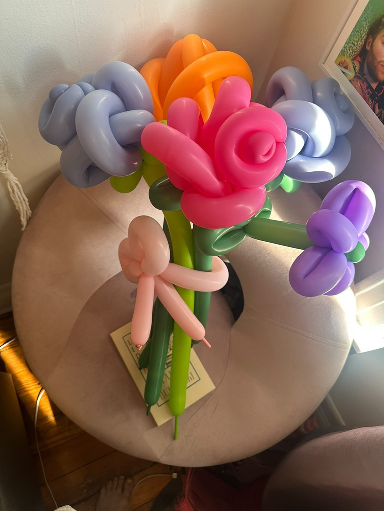 A bouquet of various balloon flowers tied with a balloon bow